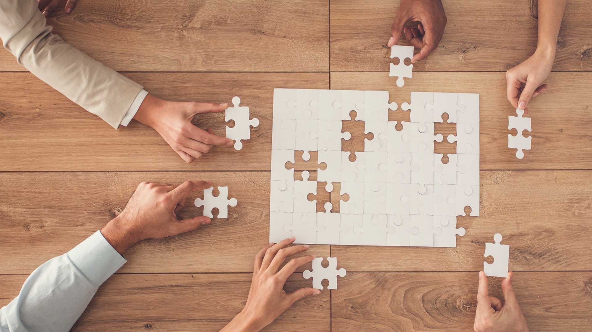 Birdseye view of people putting together a jigsaw puzzle